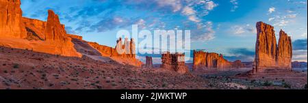 Blick am frühen Morgen auf den Abschnitt Courthouse Towers des Arches National Park, Moab, Utah. Von links - die drei Klatsch, Sheep Rock, Turm zu Babel an Stockfoto