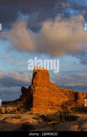Sonnenuntergang Wolken über einem Entrada Sandstein butte im Balanced Rock Abschnitt des Arches National Park, Moab, Utah. Stockfoto