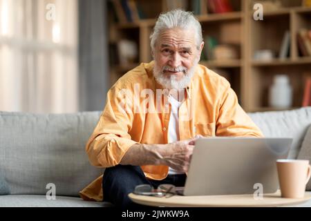 Freiberuflicher Senior-Mitarbeiter, der von zu Hause aus mit einem Laptop arbeitet Stockfoto