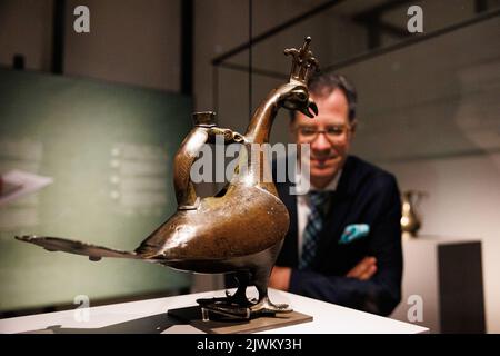 06. September 2022, Niedersachsen, Hildesheim: Martin Hoernes, Generalsekretär der Ernst von Siemens Kunststiftung, blickt bei einer Führung durch die Ausstellung auf eine Figur, die einen Pfau darstellen soll und mit Ornamenten und einer zweisprachigen Inschrift (Arabisch und Latein) geschmückt ist. Die Ausstellung 'Islam in Europa 1000-1250' widmet sich den Gemeinsamkeiten und Verflechtungen der Kulturen des Mittelalters mit Kunstobjekten aus europäischen Kirchenschätzen und aus dem Hildesheimer Domschatz und ist vom 07. September 2022 bis 12. Februar 2023 im Dommuseum Hildeshei zu sehen Stockfoto