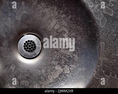 Alter Metallabfluss mit Wasserflecken und Flecken auf dem Stahlwaschbecken Stockfoto