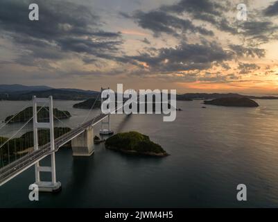 Luftaufnahme einer langen Hängebrücke zwischen kleinen Inseln zur Blauen Stunde Stockfoto