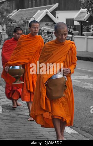 Prozessionen buddhistischer Mönche, die Almosen in Luang Prabang, Demokratische Republik Laos, sammeln Stockfoto