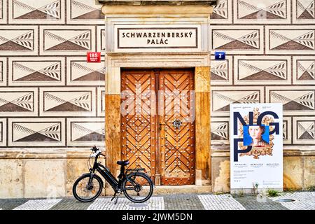 Prag, Tschechien, 30. August 2022: Fahrrad vor einem Seiteneingang mit beschlagener Holztür des Schwarzenbergpalastes, Fahrradtour Tschechien Stockfoto