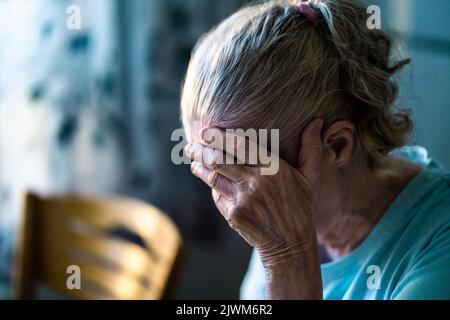 Traurige ältere Frau. Einsam vor Verlust oder krank mit Kopfschmerzen. Verärgerte Patienten im Altersheim mit Stress oder Schmerzen. Alzheimer, Depression, Senilität. Stockfoto