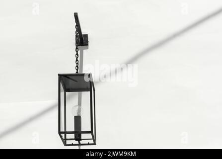 Dekorative schwarze Hängelampe an der weißen Wand Stockfoto