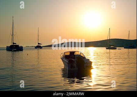 Ein Motorboot am Paros Road-Stead in Griechenland bei Sonnenuntergang Stockfoto