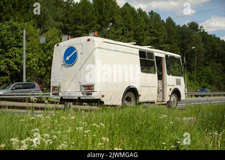 Bus auf der Straße mit Signallampen. Instandhaltung der Straße. Stockfoto