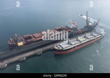 Nachodka, Russland - 31. Juli 2022: Die Seeschiffe werden an einer Anlegestelle beladen. Stockfoto