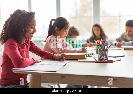 Afroamerikanische Schulmädchen Schreiben Lernen Sitzen Im Klassenzimmer Stockfoto