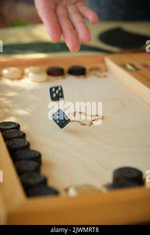 Backgammon Board mit Chips und Würfeln im Flug Stockfoto