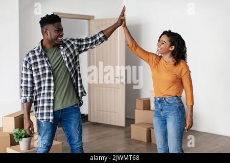 Schwarze Ehegatten Geben Hohe Fünf Stehend Unter Karton Boxen Indoor Stockfoto