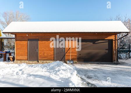 Fassade Vorderwand Blick geschlossene Tür ATV Haus Garage Werkstatt Unordnung Schuppen Lager Gebäude verschneiten Wintertag. Haus organisiert Lagerwerkzeuge Stockfoto