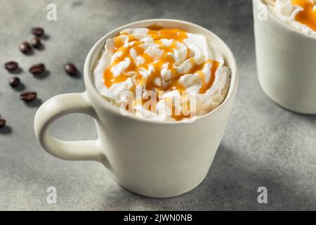 Warmes Caramel-Latte-Getränk in einer Tasse mit Schlagsahne Stockfoto
