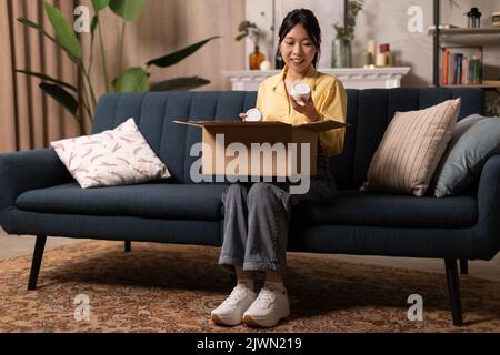 Fröhliche Japanische Weibliche Auspacken Box Hält Kosmetik-Produkte Zu Hause Stockfoto