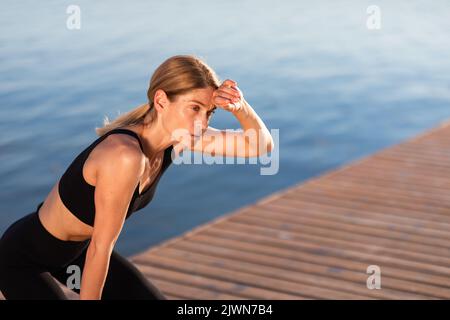 Portrait Der Erschöpften Sportlichen Lady, Die Nach Dem Outdoor Training Atem Holt Stockfoto