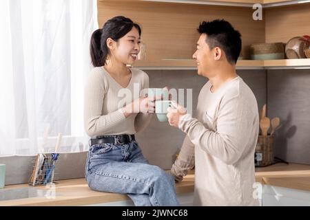 Glückliche asiatische Familie, die morgens Kaffee zu Hause genießt Stockfoto