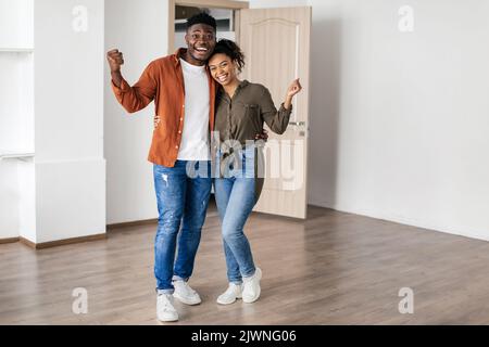 Fröhliches Schwarzes Paar Gestikuliert Ja Feiert Umzug Nach New Home Stockfoto
