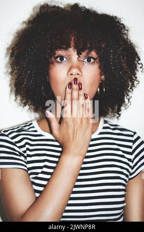 Oh, meine Güte. Studioaufnahme einer attraktiven jungen Frau, die vor grauem Hintergrund schockiert aussieht. Stockfoto