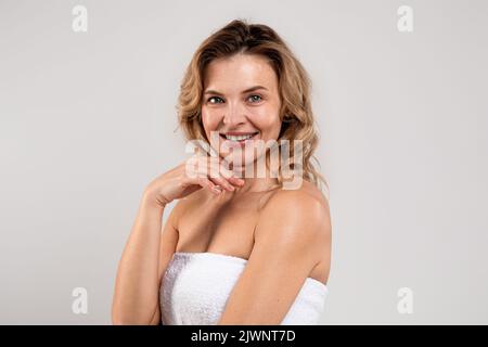 Porträt Von Happy Smiling Attraktive Frau Mittleren Alters In Badetuch Gewickelt Stockfoto