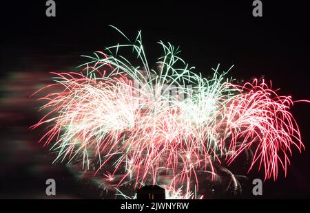 Feuerwerk explodiert über einem Gebäude in der Innenstadt von Ottawa, Kanada. Der Rauch auf der linken Seite wird durch das Feuerwerk angezündet, während der Wind den Rauch wegbläst Stockfoto