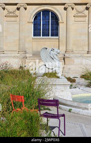 Statue eines Greifchens, das in einem kleinen Teich in den Gärten des Musée de Picardie in Amiens (Somme), Frankreich, Wasser spießt Stockfoto