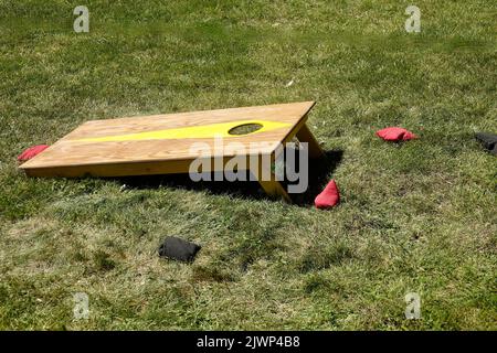 Maisloch, Bohnenbeutel werfen Spiel auf dem Rasen Stockfoto