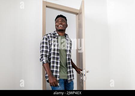 Fröhlicher Schwarzer Millennial Guy Beim Betreten Seiner Neuen Mietwohnung Stockfoto