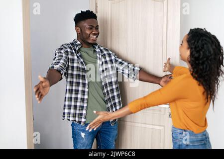 Schwarzer Mann Und Dame Treffen Sich, Strecken Sich Die Hände Zur Umarmung In Der Halle Stockfoto