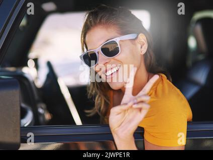 Peace out, im outta here. Eine junge Frau, die in ihrem Auto sitzt. Stockfoto