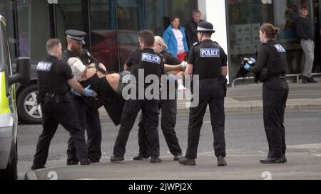 Newquay, Cornwall, Großbritannien. 06. September 2022. Eine umstrittene Spit-Maske, die auf einer Person verwendet wird, die von Polizisten aus Devon und Cornwall auf der Polizeistation Newquay festgenommen wurde. Der Vorfall ereignete sich um 16:06 Uhr an der vielbefahrenen Kreuzung von Oakleigh Terrace und Cliff Road Newquay. Die Person wurde von sechs Beamten an die Straße geklemmt und daraufhin in einen Polizeiwagen gehoben. Die Polizei von Devon und Cornwall benutzte letztes Jahr zweimal Spuhhauben oder Beißschutz bei Kindern unter elf Jahren. Kredit: Robert Taylor/Alamy Live Nachrichten Stockfoto