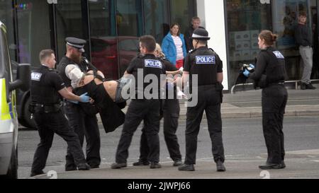 Newquay, Cornwall, Großbritannien. 06. September 2022. Eine umstrittene Spit-Maske, die auf einer Person verwendet wird, die von Polizisten aus Devon und Cornwall auf der Polizeistation Newquay festgenommen wurde. Der Vorfall ereignete sich um 16:06 Uhr an der vielbefahrenen Kreuzung von Oakleigh Terrace und Cliff Road Newquay. Die Person wurde von sechs Beamten an die Straße geklemmt und daraufhin in einen Polizeiwagen gehoben. Die Polizei von Devon und Cornwall benutzte letztes Jahr zweimal Spuhhauben oder Beißschutz bei Kindern unter elf Jahren. Kredit: Robert Taylor/Alamy Live Nachrichten Stockfoto