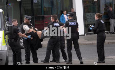 Newquay, Cornwall, Großbritannien. 06. September 2022. Eine umstrittene Spit-Maske, die auf einer Person verwendet wird, die von Polizisten aus Devon und Cornwall auf der Polizeistation Newquay festgenommen wurde. Der Vorfall ereignete sich um 16:06 Uhr an der vielbefahrenen Kreuzung von Oakleigh Terrace und Cliff Road Newquay. Die Person wurde von sechs Beamten an die Straße geklemmt und daraufhin in einen Polizeiwagen gehoben. Die Polizei von Devon und Cornwall benutzte letztes Jahr zweimal Spuhhauben oder Beißschutz bei Kindern unter elf Jahren. Kredit: Robert Taylor/Alamy Live Nachrichten Stockfoto