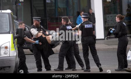 Newquay, Cornwall, Großbritannien. 06. September 2022. Eine umstrittene Spit-Maske, die auf einer Person verwendet wird, die von Polizisten aus Devon und Cornwall auf der Polizeistation Newquay festgenommen wurde. Der Vorfall ereignete sich um 16:06 Uhr an der vielbefahrenen Kreuzung von Oakleigh Terrace und Cliff Road Newquay. Die Person wurde von sechs Beamten an die Straße geklemmt und daraufhin in einen Polizeiwagen gehoben. Die Polizei von Devon und Cornwall benutzte letztes Jahr zweimal Spuhhauben oder Beißschutz bei Kindern unter elf Jahren. Kredit: Robert Taylor/Alamy Live Nachrichten Stockfoto