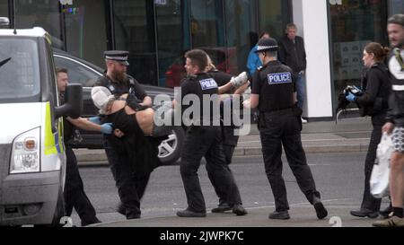 Newquay, Cornwall, Großbritannien. 06. September 2022. Eine umstrittene Spit-Maske, die auf einer Person verwendet wird, die von Polizisten aus Devon und Cornwall auf der Polizeistation Newquay festgenommen wurde. Der Vorfall ereignete sich um 16:06 Uhr an der vielbefahrenen Kreuzung von Oakleigh Terrace und Cliff Road Newquay. Die Person wurde von sechs Beamten an die Straße geklemmt und daraufhin in einen Polizeiwagen gehoben. Die Polizei von Devon und Cornwall benutzte letztes Jahr zweimal Spuhhauben oder Beißschutz bei Kindern unter elf Jahren. Kredit: Robert Taylor/Alamy Live Nachrichten Stockfoto