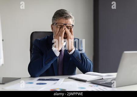 Geschäftsstress. Porträt Eines Müden Geschäftsmannes Mittleren Alters, Der Im Büro Die Augen Reibt Stockfoto