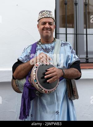 Frigiliana, Malaga, Spanien, 27. August 2022: Arabischer Musiker mit einer Derbake-Trommel und einer blauen Djellaba beim Festival der drei Kulturen in Frigiliana Stockfoto