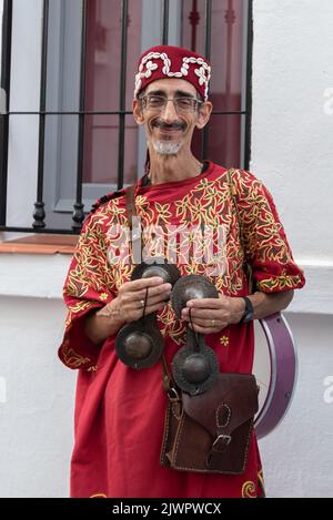 Frigiliana, Malaga, Spanien, 27. August 2022: Arabischer Musiker mit Zimbeln und roter Djellaba beim Frigiliana Three Cultures Festival Stockfoto