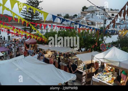 Frigiliana, Malaga, Spanien, 27. August 2022: Die Stadt feiert das Fest der drei Kulturen mit Girlanden und Menschen, die an der mittelalterlichen Marke einkaufen Stockfoto