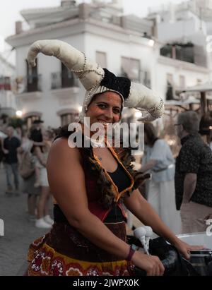 Frigiliana, Malaga, Spanien, 27. August 2022: Straßenkünstler mit mittelalterlichem Kopfschmuck aus Hörnern und großer Trommel beim Frigiliana Festival der drei Cul Stockfoto