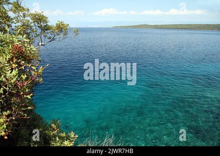 Felsküste in Kroatien mit einem Körper aus blauem Wasser - rechte Seite für Kopierraum Stockfoto