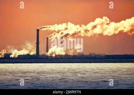 Immission. Rauchige Rohre und vergiftete Atmosphäre und Wasser des Industriegebiets Stockfoto