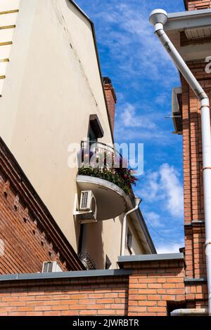 Ein süßer kleiner Balkon auf einem Stadthaus, das mit hellen Blumen geschmückt ist Stockfoto