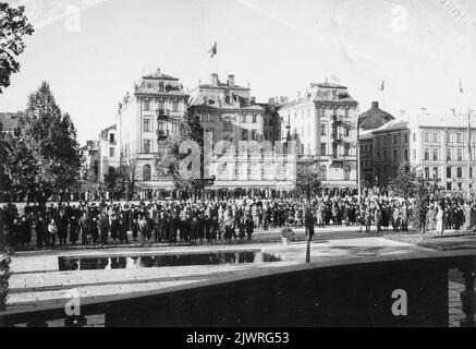 Ein großes Publikum hatte sich am 29. September 1940 versammelt, um die Einweihung des Gävle-Museums über montierte Lautsprecher zu hören. Weiter hinten im Bild ist zu sehen, dass sich eine große Anzahl von Zuschauern auch auf der anderen Seite von Gavleån im Grand Hotel befand. En stor publik hade samlats den 29 september 1940 för att lyssna till invigningen AV Gävle Museum via uppmonterade högtalare. Längre bak i bilden går att se att en stor männd publik även fanns på andra sidan Gavleån vid Grand Hotel. Stockfoto