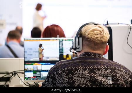 Audio-Video-Lichttechniker balancieren und justieren Schallquellen durch die Verwendung von Equalizer bei einer Geschäftskonferenz oder einer Geschäftsschulung Stockfoto