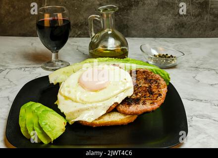 Hamburger mit Spiegelei, Salat und Avocado. Stockfoto