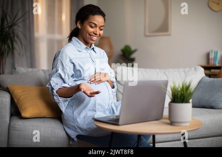 Schwanger African Lady Machen Video-Anruf Im Gespräch Mit Laptop Drinnen Stockfoto