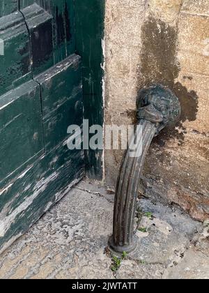 Casarano, Italien. Ein gewölbter Metallpfosten im Vintage-Stil schützt den Eingang in ein Gebäude im historischen Zentrum. Stockfoto