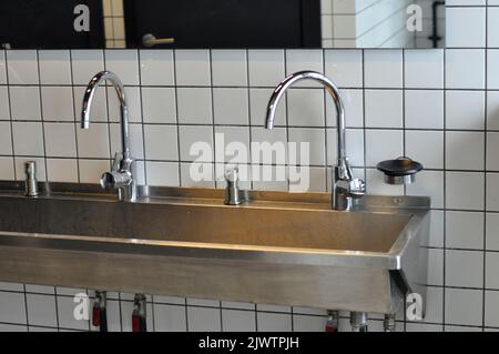 Handwaschbecken aus Edelstahl in einem modernen Gefängnis. Stockfoto