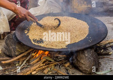 Teffkörner, die in Äthiopien für Injera-Brot geröstet werden Stockfoto